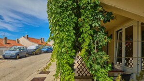 A residential street with parked cars and a house with a vine-covered wall. - Maraština Suites (Dubrovnik)