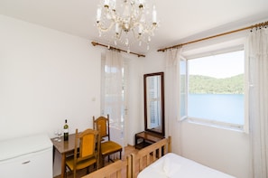 Chambre Triple, plusieurs lits, balcon, vue mer | Restauration dans la chambre