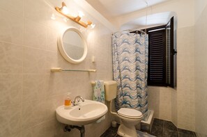 A bathroom with a sink, toilet, and shower curtain. - Rooms Mozara (Dubrovnik)