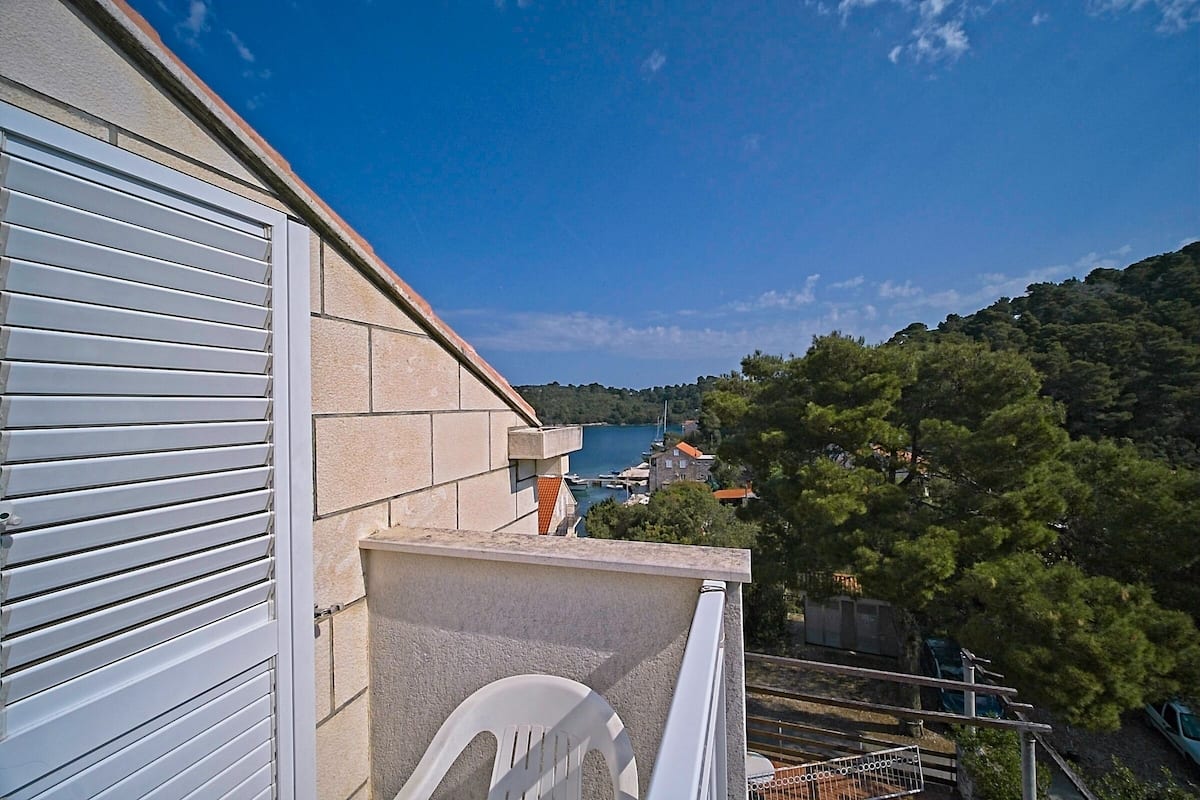 A balcony with a view of a coastal town and a body of water.