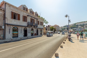 A street with a building featuring arched doorways and a balcony. - Boutique Villa Root (Dubrovnik)