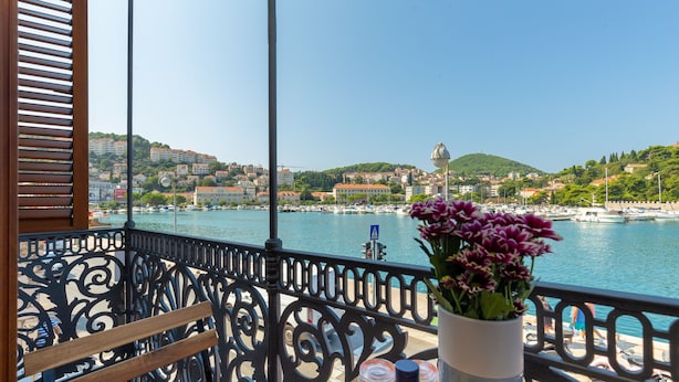 Ein Balkon mit Blick auf einen Hafen und Gebäude am Wasser.