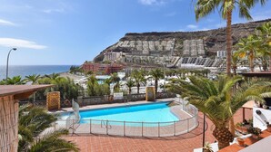 A swimming pool with a view of a coastal area and buildings in the background.