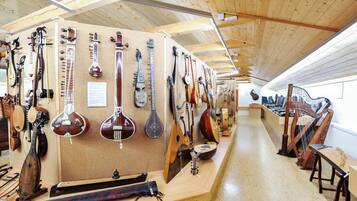 A room with wooden ceilings and walls, displaying various string instruments.