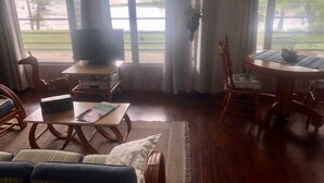 A living room with a TV, sofa, and dining table.
