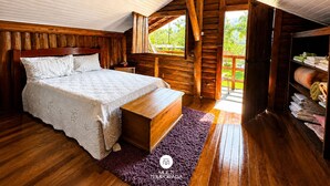 A wooden cabin bedroom with a bed, bench, and a view of greenery outside. - Sítio Morada do Pai com Sinuca e Piscina - Canelinha - SC (Canelinha)