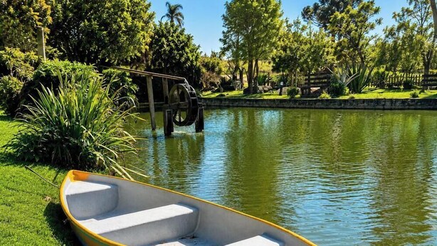 A boat docked near a water body with a bridge in the background. - Sítio Morada do Pai com Sinuca e Piscina - Canelinha - SC (Canelinha)