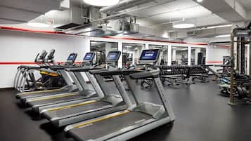 A gym with treadmills, weight machines, and free weights.