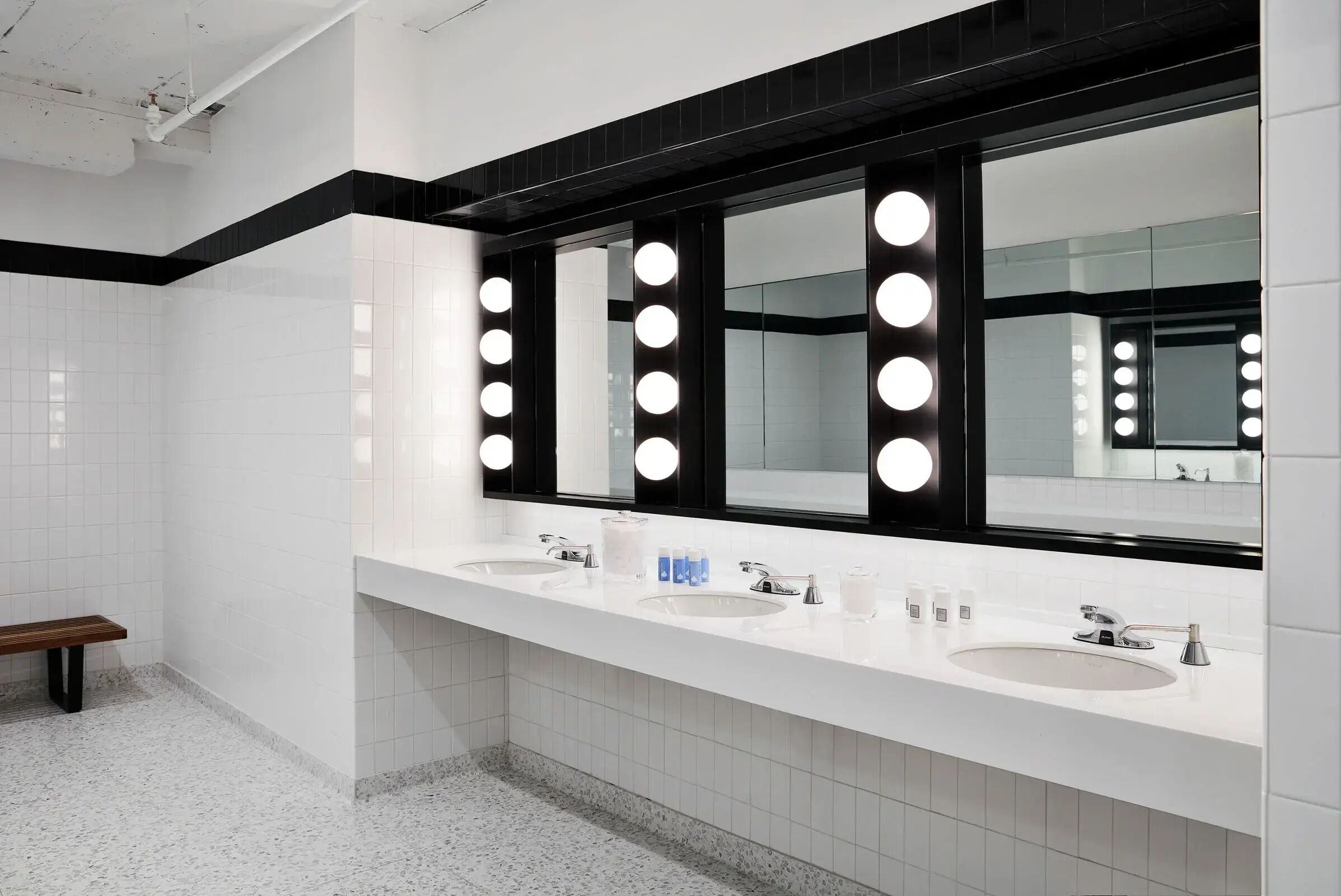 Ein modernes Badezimmer mit zwei Waschbecken, einer Ablage und einem beleuchteten Spiegel.