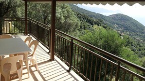 A covered outdoor area with a table and chairs, overlooking a mountainous landscape. - Nice apartment for 4 people with A/C, WIFI, TV, patio, pets allowed and panoramic view (Partinello)