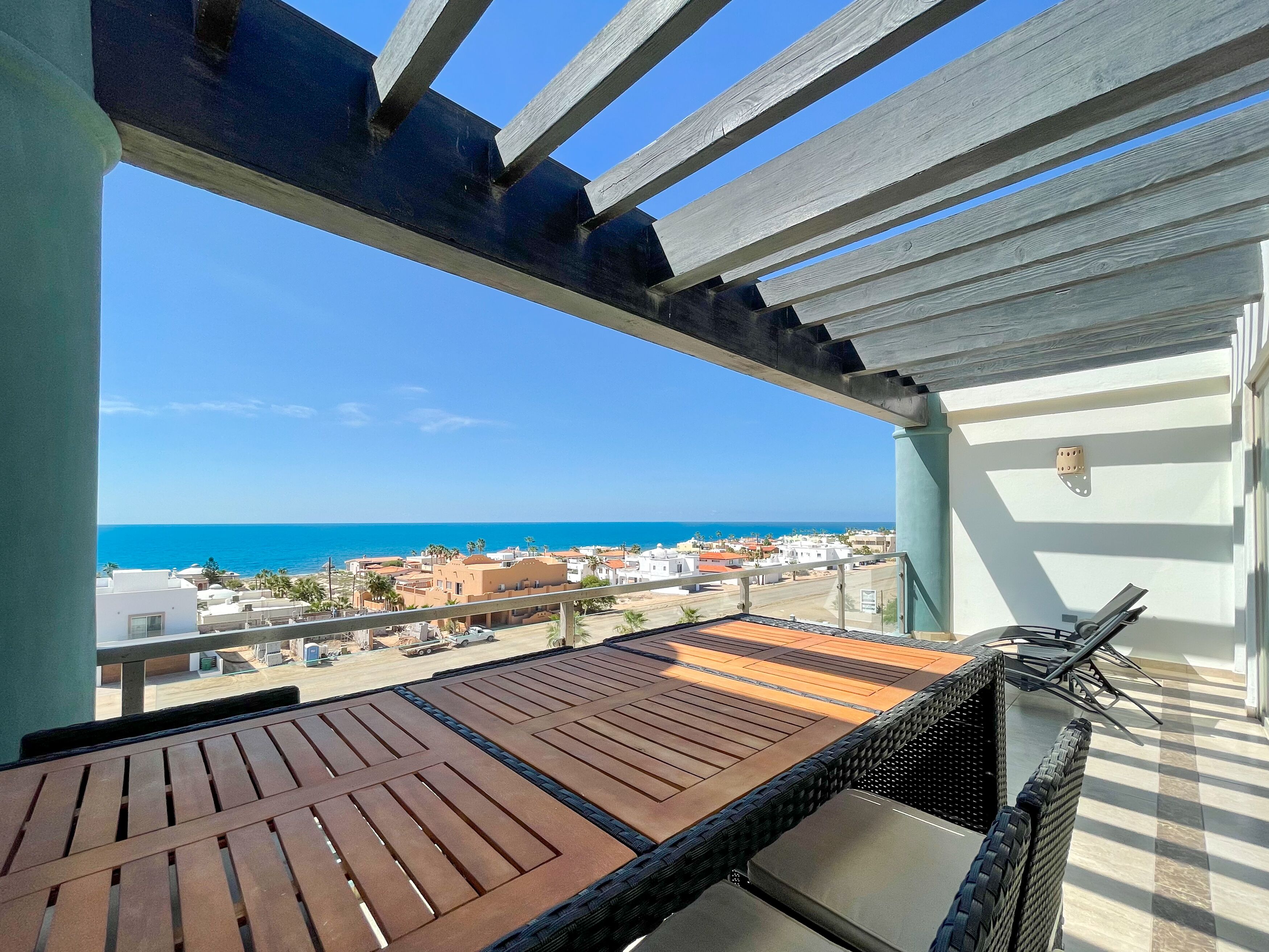 A balcony with a view of the sea and buildings.