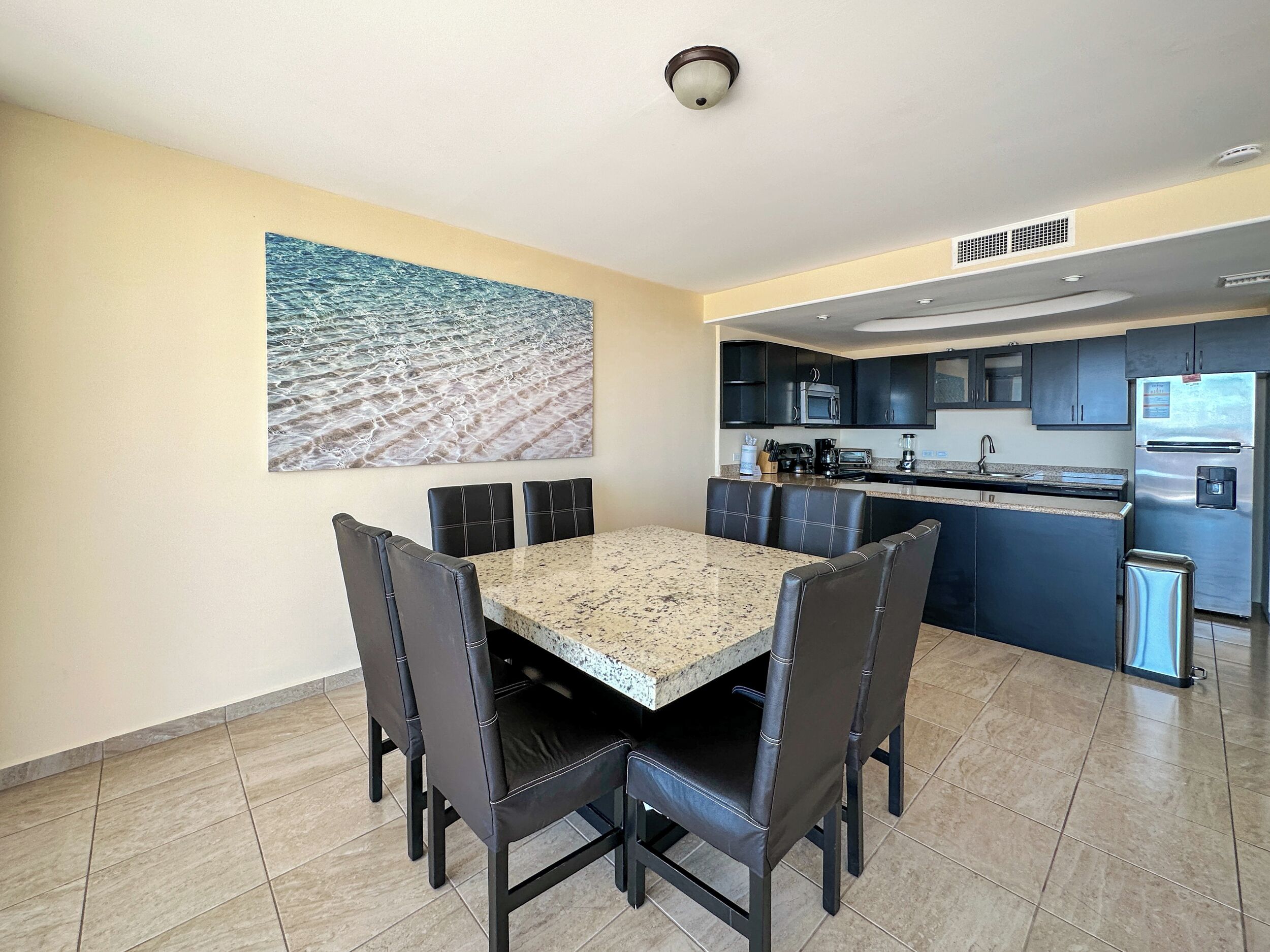 A modern kitchen with dark cabinets, stainless steel appliances, and a granite countertop.
