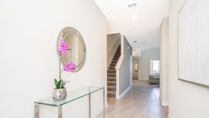 A hallway with a glass console table, a mirror, and a staircase. - (AG2770) Storey Lake VILLA 5/5, Private Pool & Free Waterpark (Kissimmee)