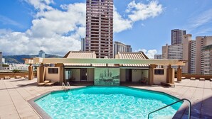 A rooftop swimming pool with lounge chairs and a view of tall buildings. - Great Location In Wakiki, Walking Distance To Beach, Shopping, Dining! (Honolulu)