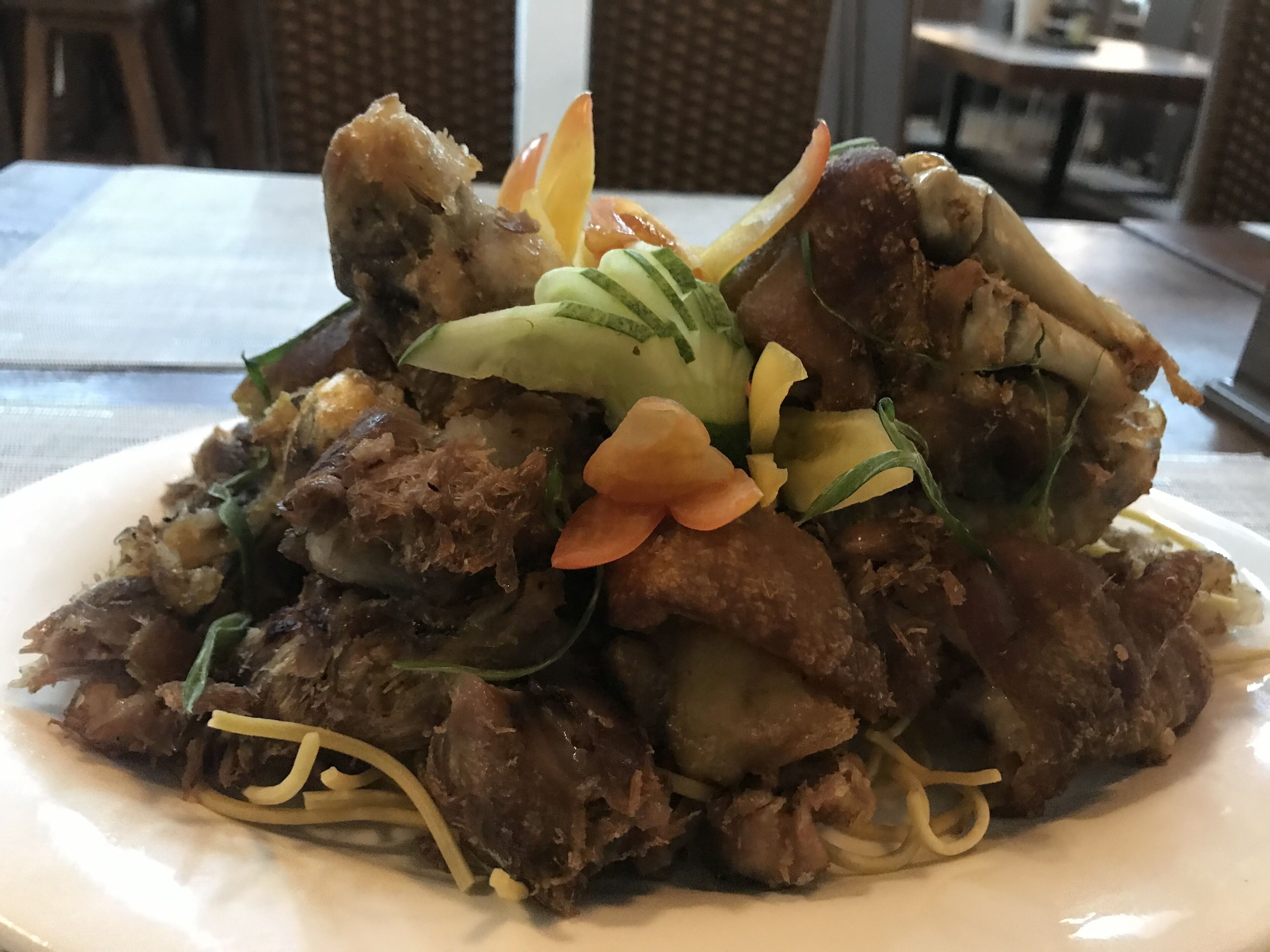 A plate of food with various ingredients, including meat, vegetables, and noodles.