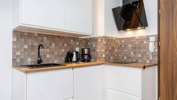 Kylskåp, spishäll, kaffe- och tebryggare och grytor/köksredskap