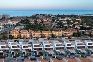 A residential area with modern apartment buildings, a swimming pool, and a view of the sea. - Fidalsa 5 Stars Premium (El Campello)
