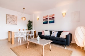 Una sala de estar moderna con comedor, un sofá y una mesa de centro.