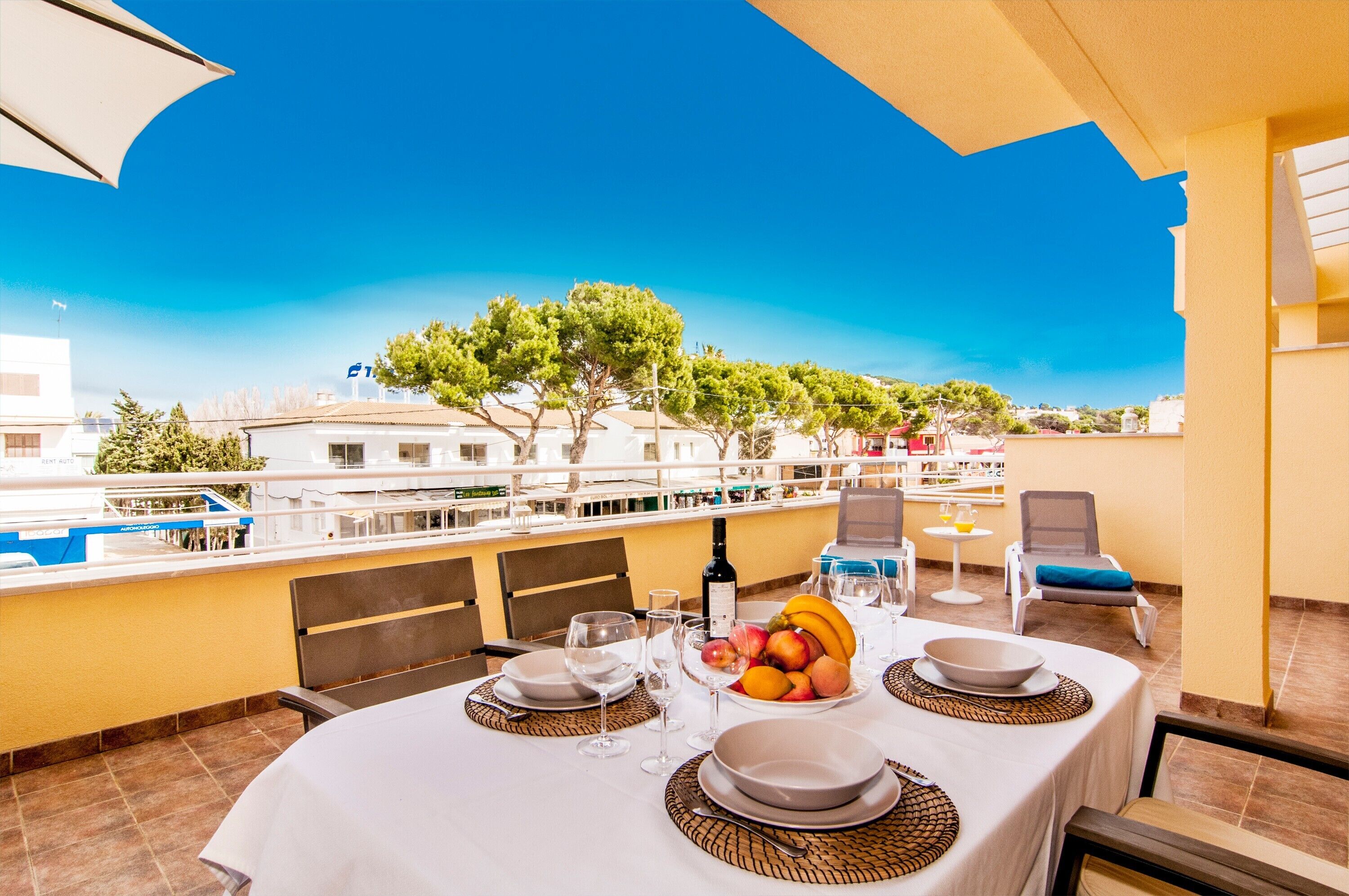 A table set for dining with a view of buildings and trees.