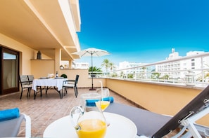 Un balcón con una mesa dispuesta para el desayuno, una silla y vistas a la ciudad.