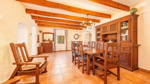 A dining area with wooden furniture, a chandelier, and a wooden cabinet with glass doors.