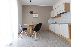 A modern kitchen with a dining table, chairs, and cabinets.