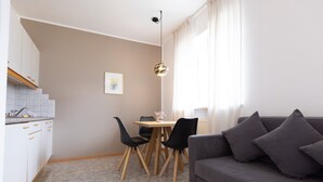 Een moderne woonruimte met een eethoek, een bank en een keuken.