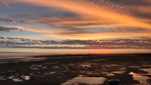 Auringonlasku tasaisella maisemalla, jossa horisontti on selkeästi näkyvissä.
