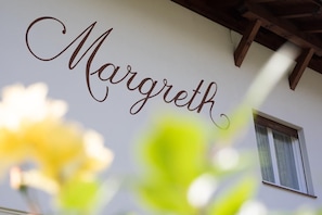 Un mur sur lequel est inscrit le nom « Margreth » en lettres cursives.