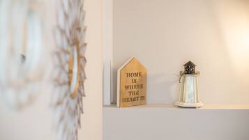 Een muur met een houten bord waarop staat 'HOME IS WHERE THE HEART IS' en een witte lantaarn.