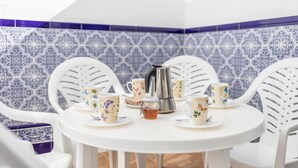 A white table with floral-patterned cups and saucers, a silver coffee pot, and a small jar of honey. - Newly Renovated Apartment “Conil Centro” with Wi-Fi, Terrace & Air Conditioning; Parking Available (Conil de la Frontera)
