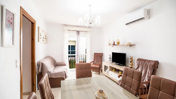A living room with a sofa, chairs, a TV, and a chandelier. - Newly Renovated Apartment “Conil Centro” with Wi-Fi, Terrace & Air Conditioning; Parking Available (Conil de la Frontera)