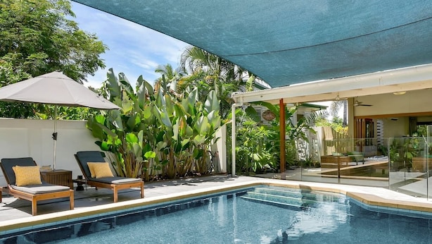 A swimming pool with lounge chairs and a covered area. - Luxurious Family Villa with Private Pool, Nestled in Cairns' Tropical Paradise (Whitfield)