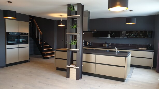 A modern kitchen with built-in appliances, a central island, and a staircase leading to an upper level. - Vacation home for 20 people, fireplace, sauna, 10 rooms, 10 bathrooms, very large, distant view (Altenberg)