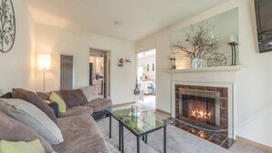 A living room with a fireplace, a sofa, a glass coffee table, and a lamp. - Silicon Beach Escape (Los Angeles)