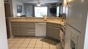 A kitchen with a dishwasher, a sink, a ceiling fan, and a window. - Hillside Hideaway ~ Spacious Poolside 2 bed 2 bath condo (Branson)