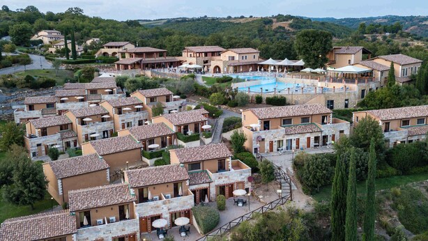Ein Resort mit mehreren Villen, einem zentralen Pool und umliegender Bepflanzung.