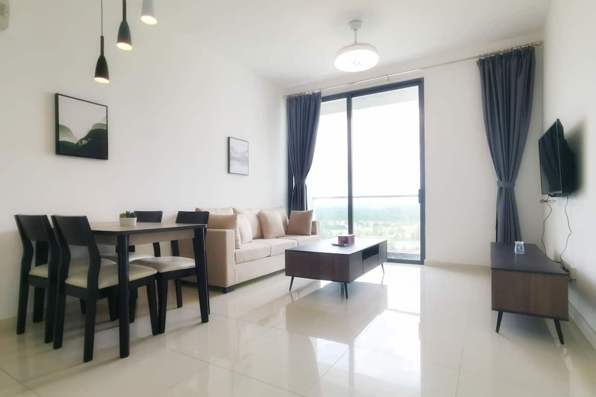A modern living room with a dining area, a sofa, a coffee table, and a TV on a stand.