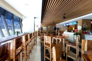 A modern restaurant interior with wooden furniture and a counter area.