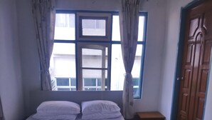 A bedroom with a bed, a window, a wooden wardrobe, and a small bedside table. - Diamond Star Guest House (Nyaungshwe)