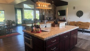 A spacious kitchen with a large island, built-in oven, and granite countertops. - Country setting close to Glacier National Park (Columbia Falls)