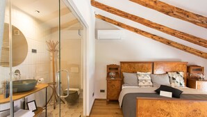 A bedroom with a wooden headboard, a large bed, and a bedside table. - Špacapanova hiša (Komen)