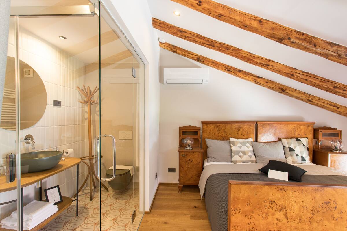 A bedroom with a wooden headboard, a large bed, and a bedside table.
