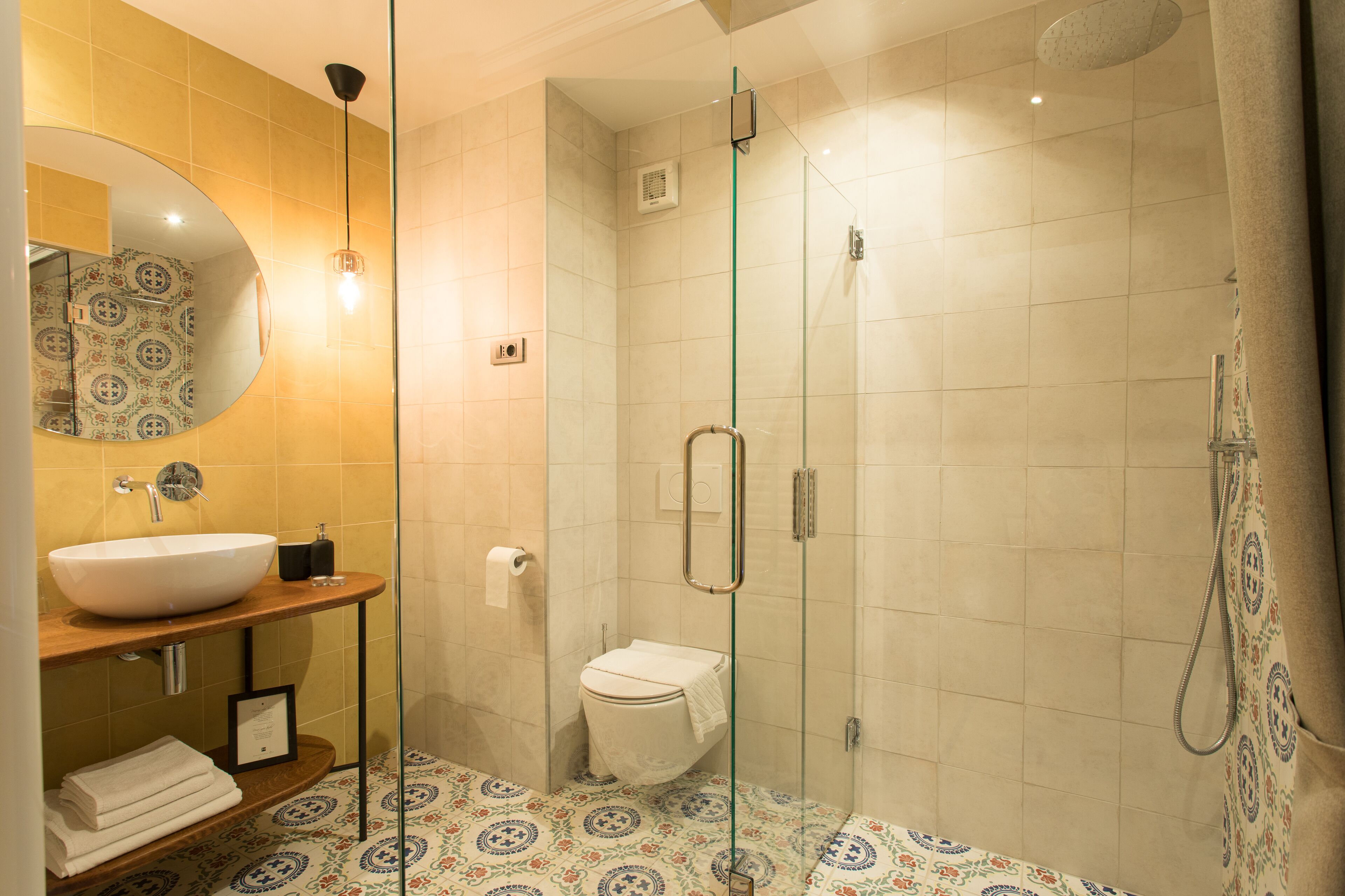 A modern bathroom with a large sink, a toilet, and a glass-enclosed shower area.