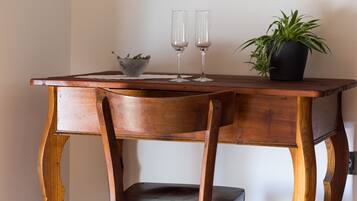 A wooden desk with two glasses and a potted plant.