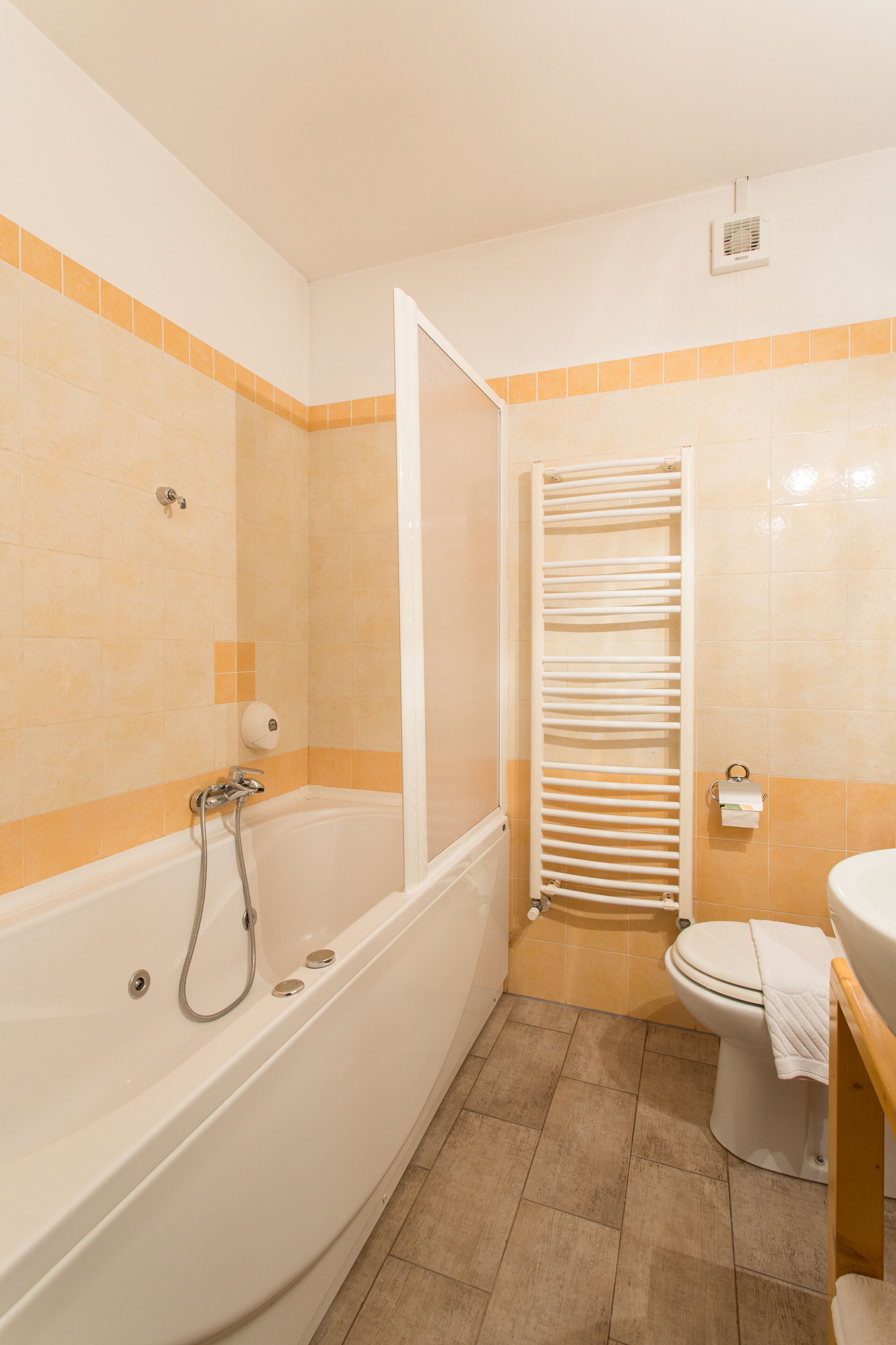 A bathroom with a bathtub, toilet, and towel rack.