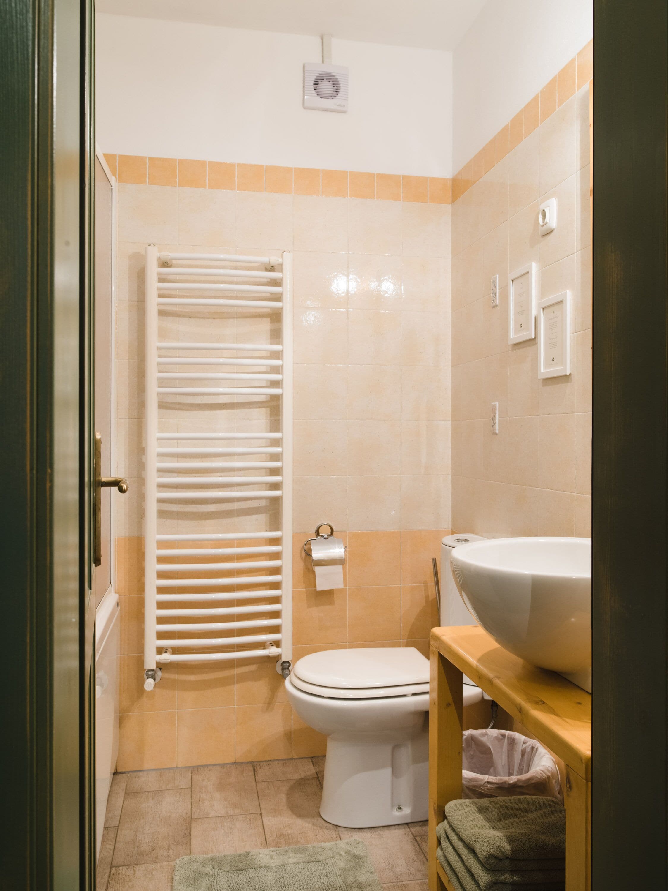Een badkamer met een toilet, een handdoekhouder, een wastafel en een prullenbak.