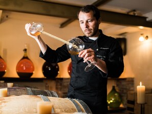 A person pouring a drink from a bottle into a glass.