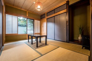 Traditional Japanese-style room with tatami flooring, shoji screens, and a low wooden table.