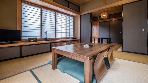 A traditional Japanese room with tatami flooring, a wooden dining table, and sliding doors.
